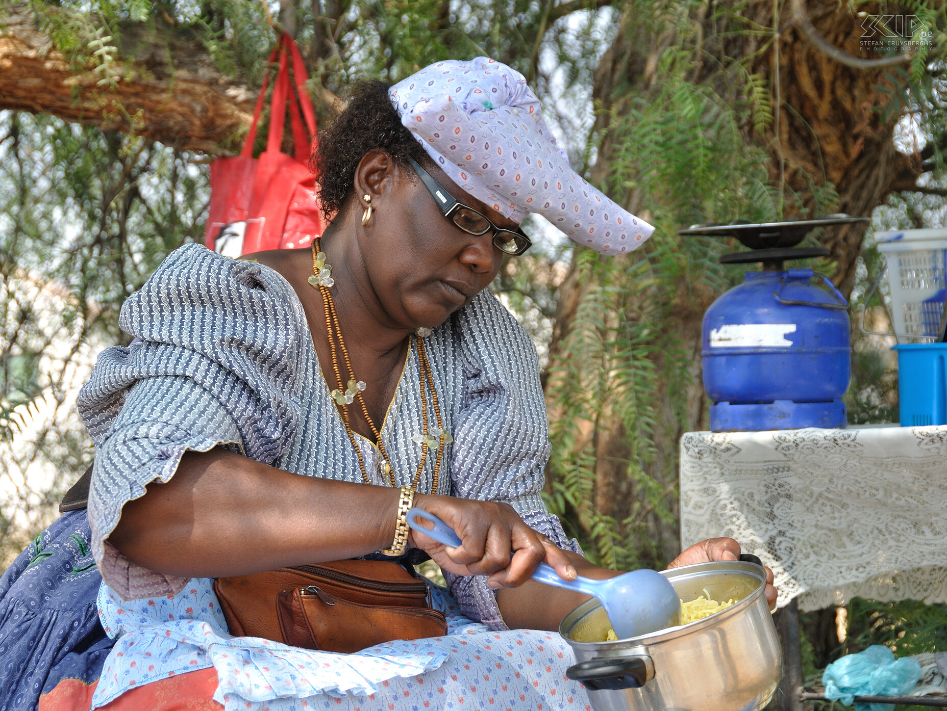 Okakarara - Herero woman In Okakarara we were introduced to the Herero culture. This woman in traditional clothing is cooking. Stefan Cruysberghs